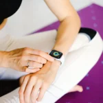 Manos de mujer configurando el SmartWatch Amazfit Active para activar el monitoreo, su GPS personal del bienestar